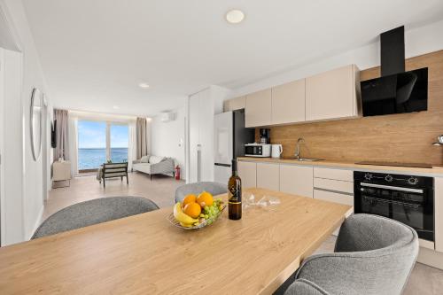 a kitchen with a table with a bowl of fruit on it at Calypso Residence in Umag