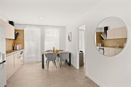 a kitchen and dining room with a table and a mirror at Calypso Residence in Umag