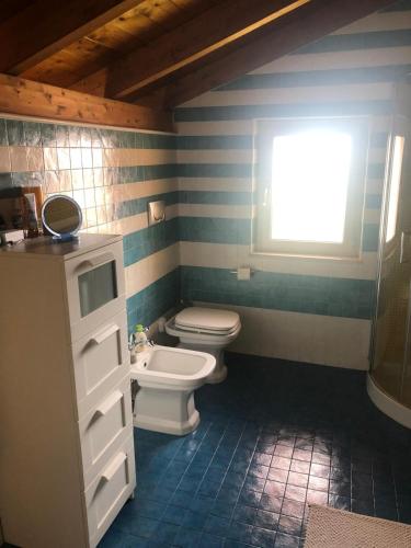 a bathroom with a toilet and a sink and a window at La casa di Carola in Termoli