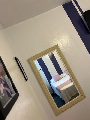 a mirror on a wall with a bed in a room at POUSADA MAORI Boiçucanga in Boicucanga