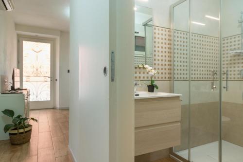 a bathroom with a sink and a glass shower at Villanova Apartment in Cagliari