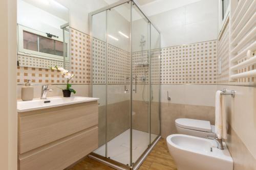 a bathroom with a shower and a toilet and a sink at Villanova Apartment in Cagliari