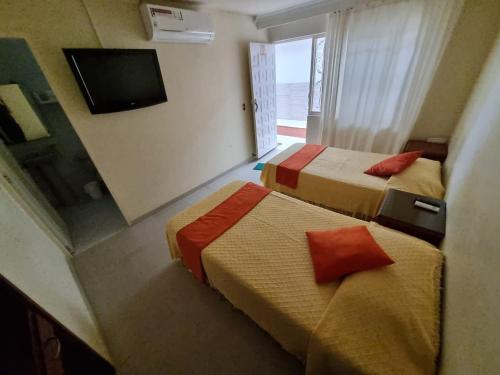 a hotel room with two beds and a television at Hotel Napolitano in Villavicencio