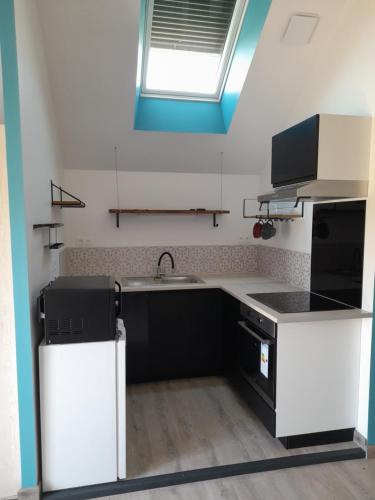 une petite cuisine avec un évier et un évier dans l'établissement Entre Loire et Vallée, à Saint-Germain-des-Prés