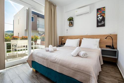 a bedroom with a large bed and a balcony at Ethra Apartment T in Skala Rachoniou