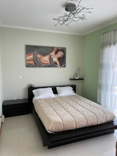 a bedroom with a bed and a painting on the wall at Oásis da Praia in Tocha