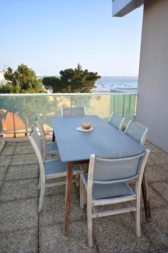 d'une table bleue et de chaises sur un balcon donnant sur l'océan. dans l'établissement magnifique T3 vue mer et direct plage, à Arcachon