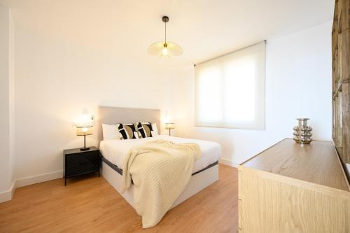 a white bedroom with a bed and a window at Skymar Palmeras 2 bedrooms & pool by 10Tosea in Fuengirola