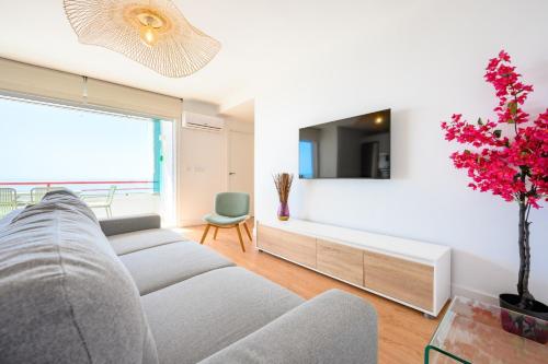 a living room with a couch and a tv at Skymar Palmeras 2 bedrooms & pool by 10Tosea in Fuengirola