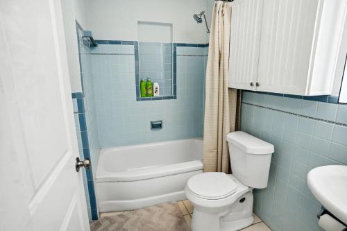 een badkamer met toilet, bad en wastafel bij Papa John's in St Pete Beach