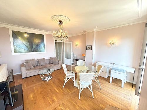 un salon avec un canapé, une table et des chaises dans l'établissement Appartement 3p vue mer proche plages et congrès, à Cannes