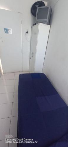 a room with a bed with a laptop on top of it at Hostel Canarios in Palhoça