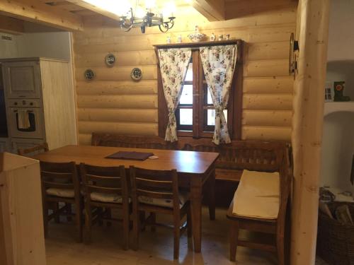 a dining room with a table and chairs and a window at Drevenica Vanesa in Terchová