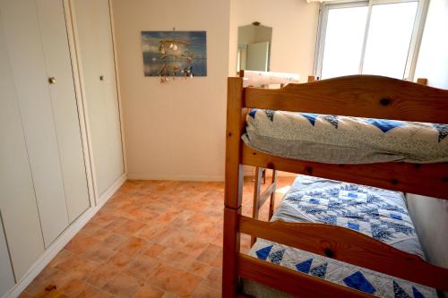 une chambre avec deux lits superposés dans une pièce dans l'établissement magnifique T3 vue mer et direct plage, à Arcachon