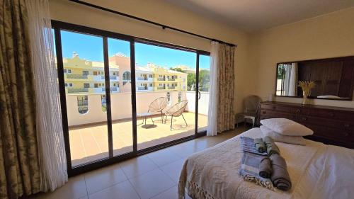 a bedroom with a bed and a large window with a balcony at Villa OceanKokia in Albufeira