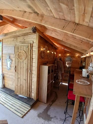 Cette chambre se trouve dans une cabane en rondins dotée d'une porte. dans l'établissement L'Ô Ré des Bois, hébergement insolite Clair de Lune, Bain norvégien, sauna, kota, à Laussonne