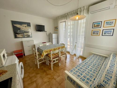 a living room with a table and chairs in it at Flat 180mt from the beach in Porto Santa Margherita di Caorle