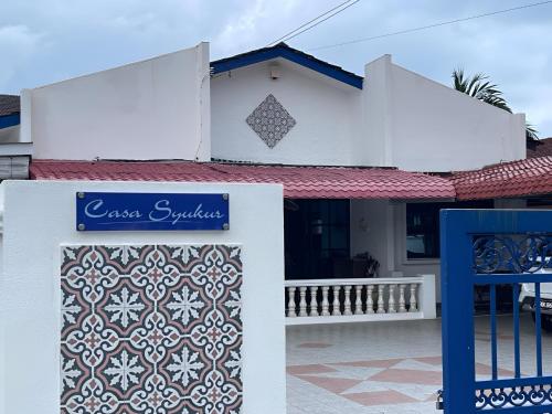 a house with a gate and a sign in front of it at Casa Syukur in Cukai