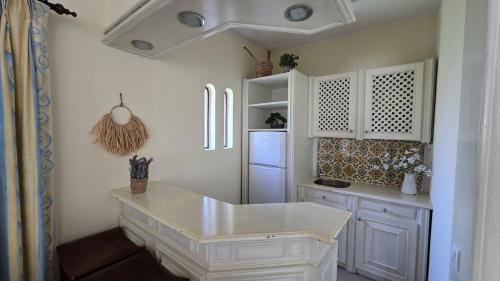 a kitchen with white cabinets and a white refrigerator at Villa OceanKokia in Albufeira