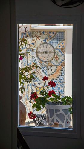 a window with a clock and a potted plant at Regina Stella in Lascari