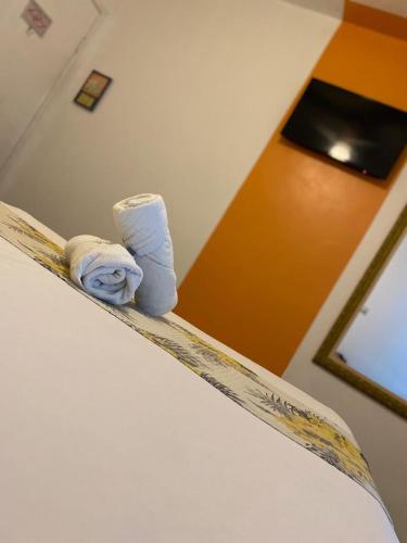 a bed with two rolled towels on top of it at POUSADA MAORI Boiçucanga in Boicucanga
