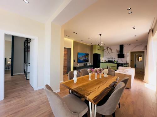 a dining room with a wooden table and chairs at Seafront Penthouse with Sunset Views & Jacuzzi in Vlorë