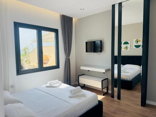 a hotel room with two beds and a mirror at Seafront Penthouse with Sunset Views & Jacuzzi in Vlorë