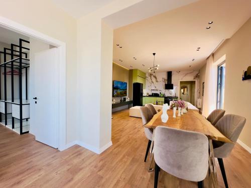 a dining room and living room with a table and chairs at Seafront Penthouse with Sunset Views & Jacuzzi in Vlorë