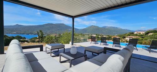 un soggiorno con vista sull'acqua e sulle montagne di Villa Haut Standing Stella Di Mare vue panoramique a Propriano