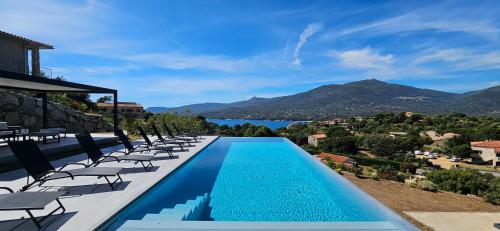 une piscine avec des chaises et une vue sur l'eau dans l'établissement Villa Haut Standing Stella Di Mare vue panoramique, à Propriano