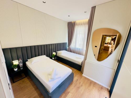 a hotel room with a bed and a mirror at Seafront Penthouse with Sunset Views & Jacuzzi in Vlorë