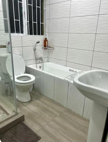 a white bathroom with a toilet and a sink at 4beds,3 bedrooms,Braai,Full kitchen in Tzaneen