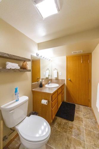 a bathroom with a white toilet and a sink at Spacious 3BR Family Retreat w Fire Pit BBQ Smart TVs & More in Spokane Valley