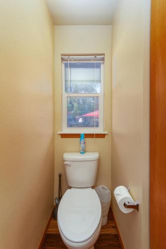 a white toilet in a bathroom with a window at Spacious 3BR Family Retreat w Fire Pit BBQ Smart TVs & More in Spokane Valley