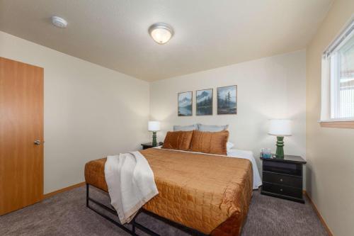 a bedroom with a bed and two lamps and a window at Spacious 3BR Family Retreat w Fire Pit BBQ Smart TVs & More in Spokane Valley