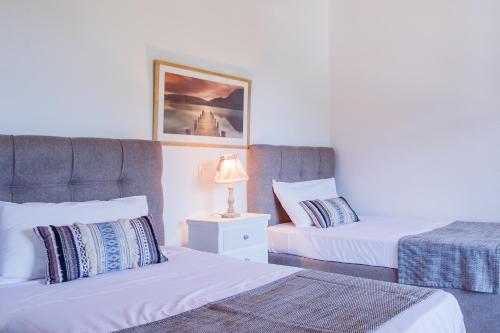 a bedroom with two beds and a lamp on a night stand at Loggos Summer House in Vasilikos