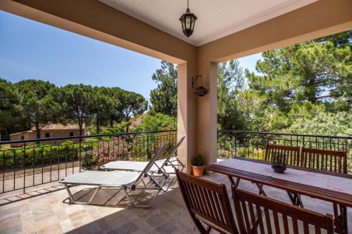 a patio with a table and chairs on a balcony at Loggos Summer House in Vasilikos