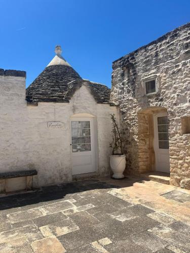 a building with two white doors and a potted plant at Masseria Luco in Martina Franca
