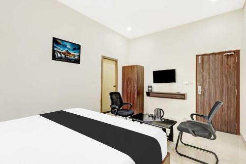 a hotel room with a bed and two chairs at Townhouse Dabagardens Near Railway Station in Visakhapatnam