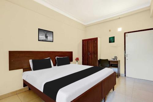 a bedroom with a large bed and a desk at Hotel O Jagadamba Junction in Visakhapatnam