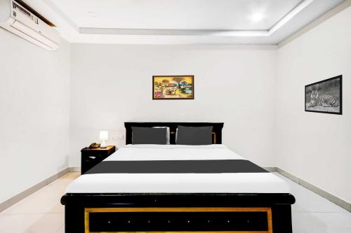 1 dormitorio con 1 cama en blanco y negro en Super Collection O Daba Garden Road, en Visakhapatnam