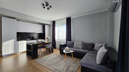 una sala de estar con un sofá y una mesa en Royal Apartments Otopeni DN, en Otopeni