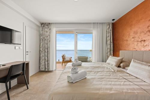 a bedroom with a large bed with a view of the ocean at Calypso Residence in Umag