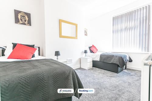 a bedroom with two beds and a red pillow at Spacious 3 BR House in PR6 Free Parking & WiFi Sleeps 6 in Chorley