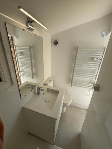 a white bathroom with a sink and a toilet at Appartement T3 - Plage à 500m in Saint-Nazaire