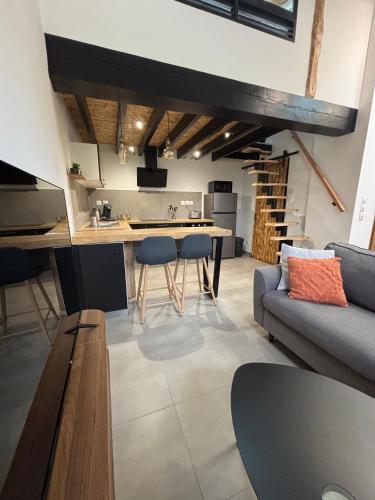 une cuisine et un salon avec un canapé et une table dans l'établissement Appartement cosy et équipé, à Saint-Porquier