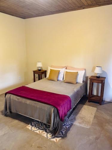 a bedroom with a large bed with two night stands at Hospedagem Fernandes Cunha, SP in Cunha