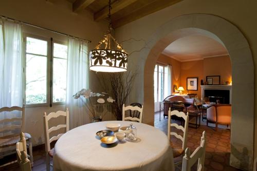 une salle à manger avec une table et un lustre dans l'établissement Le Mas de l'Embellie, à Arles