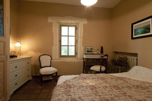 une chambre avec un lit et deux chaises et une fenêtre dans l'établissement Le Mas de l'Embellie, à Arles