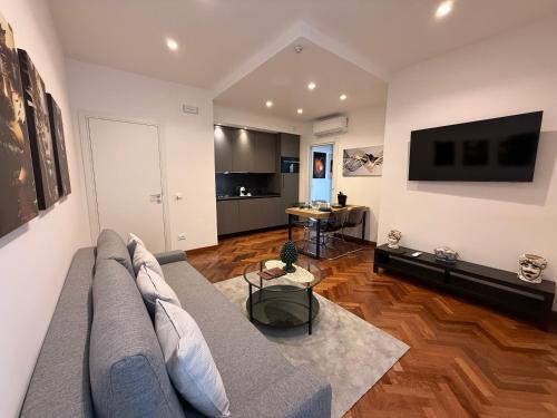 a living room with a couch and a flat screen tv at Teddy House Ortigia in Syracuse